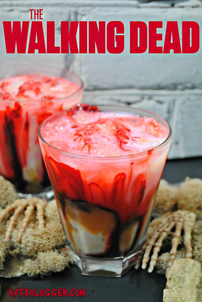 A zombie cocktail with red, white, & dark colors surrounded by skeleton hands with The Walking Dead caption above it