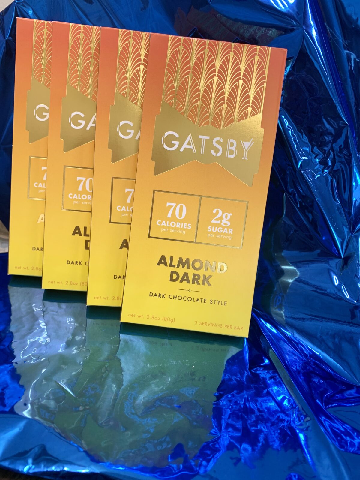 gatsby almond dark chocolate bars against a blue shiny background